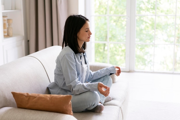 Mujer joven haciendo yoga en casa