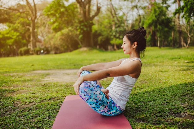 Mujer joven haciendo yoga y disfrutando del día soleado