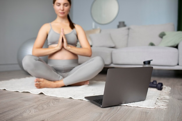 Mujer joven haciendo yoga durante el embarazo