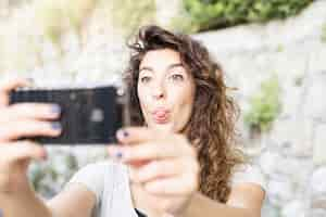 Foto gratuita mujer joven haciéndose un selfie