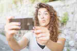 Foto gratuita mujer joven haciéndose un selfie
