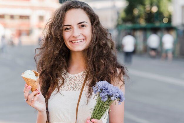 Mujer joven con helado y flores
