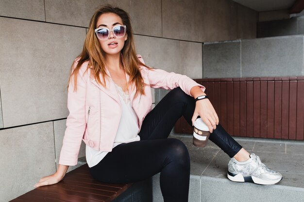 Mujer joven hermosa con estilo hipster en chaqueta de cuero rosa