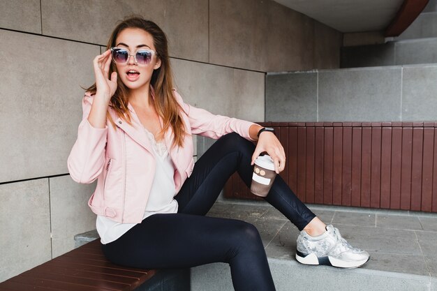 Mujer joven hermosa con estilo hipster en chaqueta de cuero rosa