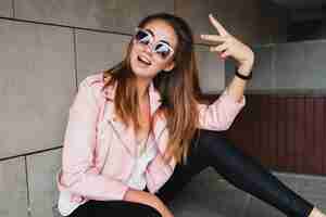 Foto gratuita mujer joven hermosa con estilo hipster en chaqueta de cuero rosa