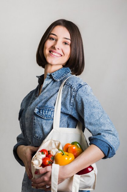 Mujer joven hermosa que sostiene verduras orgánicas