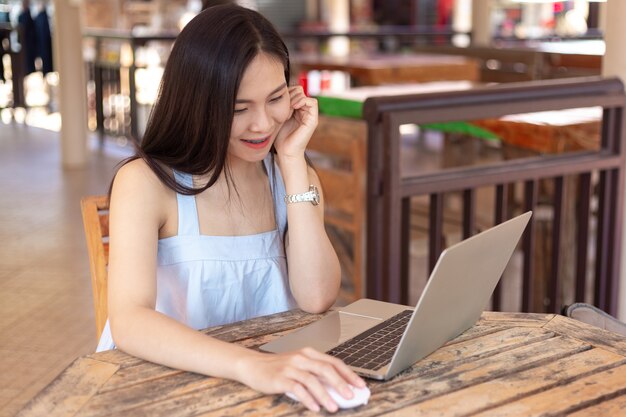 Mujer joven hermosa que usa la computadora portátil