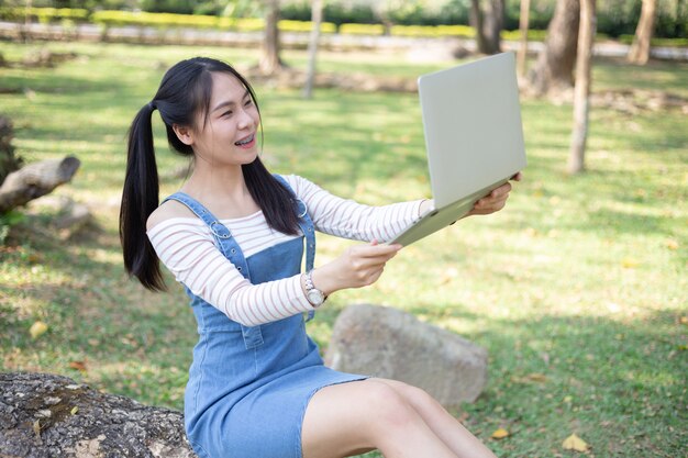 Mujer joven hermosa que usa la computadora portátil