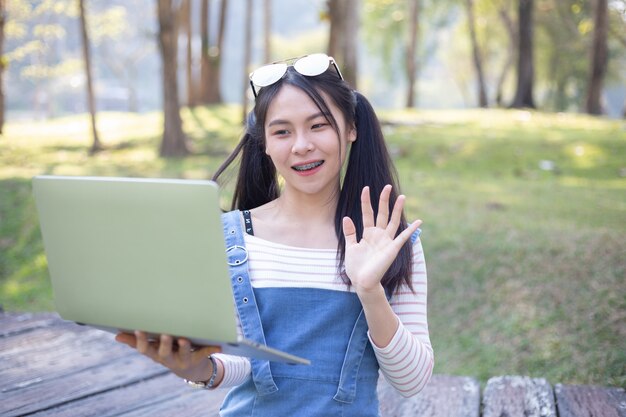 Mujer joven hermosa que usa la computadora portátil