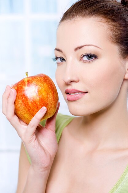 Mujer joven hermosa sensibilidad con manzana - en el interior