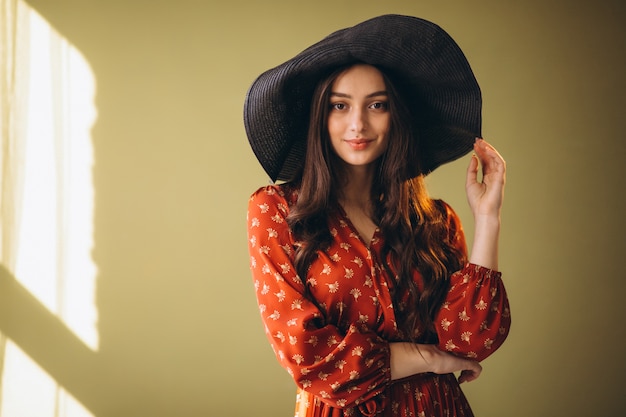 Mujer joven en un hermoso vestido y sombrero