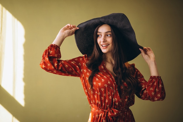 Mujer joven en un hermoso vestido y sombrero