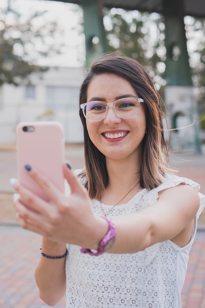 Mujer joven hispana haciendo una videollamada con su teléfono