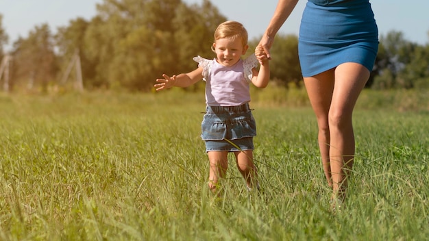 Mujer joven hodling manos con una niña