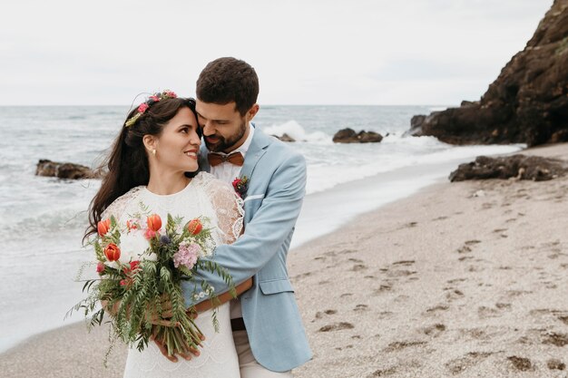 Mujer joven y hombre con una boda en la playa