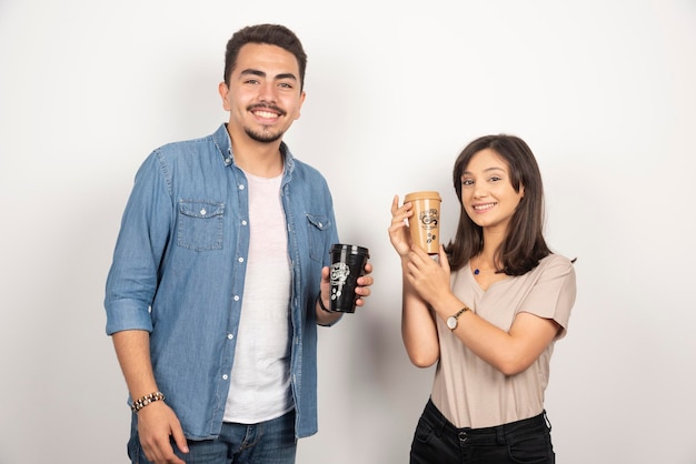 Mujer joven y hombre compartiendo café en blanco.