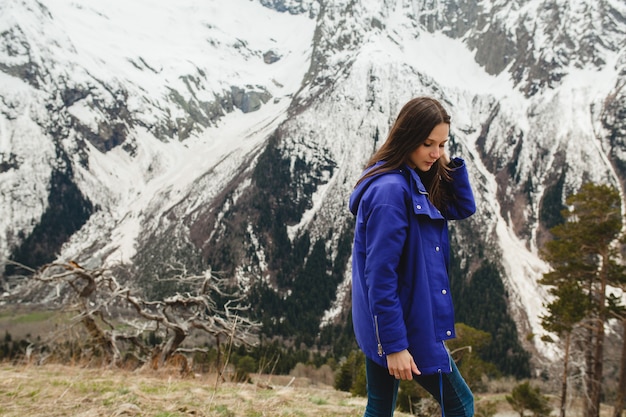 Mujer joven inconformista caminando en las montañas