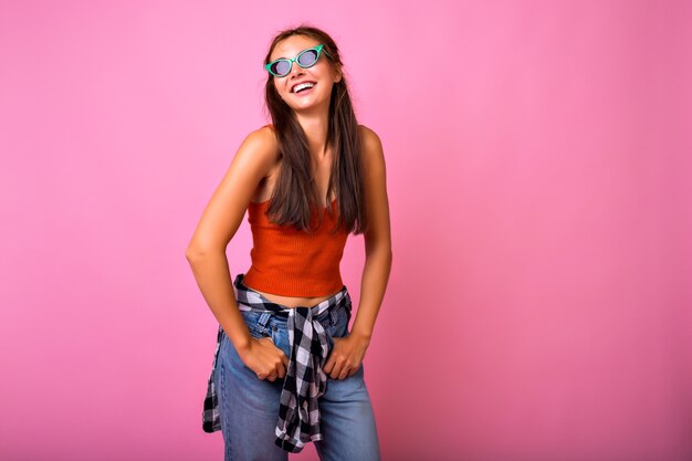 Mujer joven inconformista divirtiéndose mostrando lengua y posando