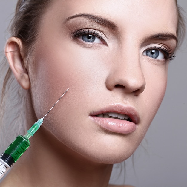 Mujer joven inyectando para un tratamiento de belleza