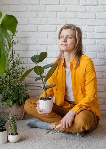 Foto gratuita mujer joven en jardinería camisa amarilla