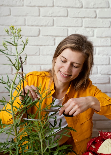 Foto gratuita mujer joven en jardinería camisa amarilla