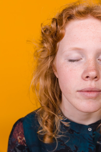 Mujer joven jengibre pacífica con los ojos cerrados