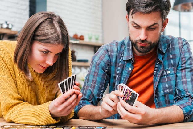 Mujer joven jugando a las cartas en casa