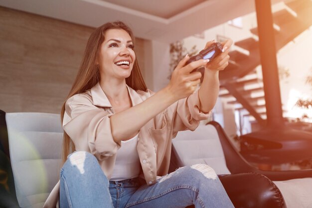 mujer joven jugando playstation en casa