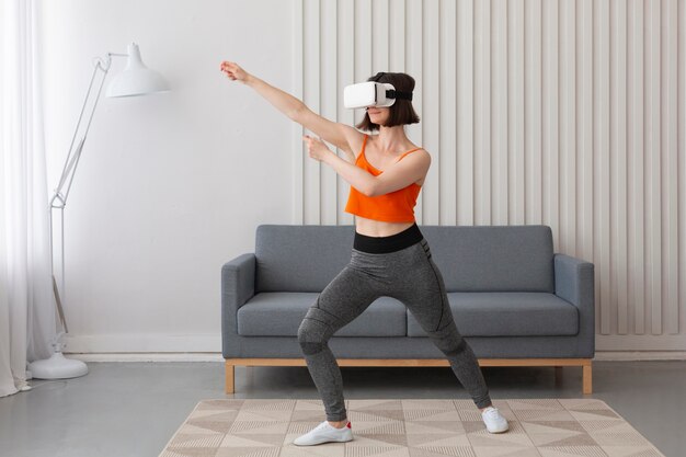 Mujer joven jugando videojuegos mientras usa gafas de realidad virtual