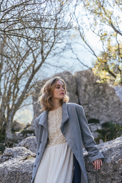 Mujer joven junto a rocas mirando