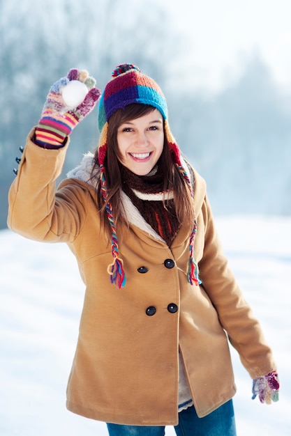 Mujer joven lanzando bolas de nieve