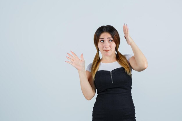 Mujer joven levantando las manos por encima de la cabeza