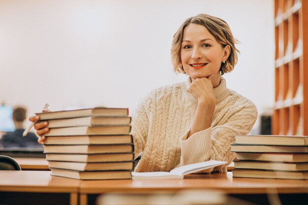 Mujer joven leyendo en la biblioteca