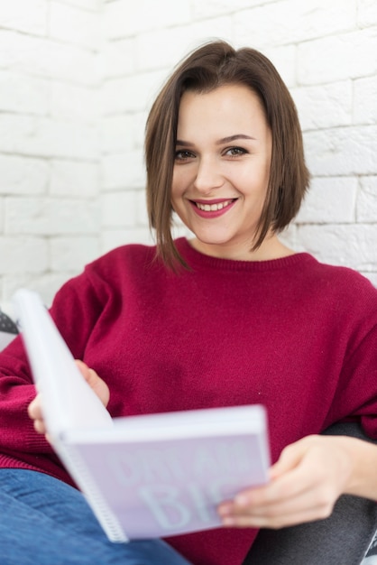 Mujer joven leyendo en casa