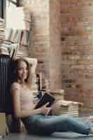 Foto gratuita mujer joven leyendo un libro en casa