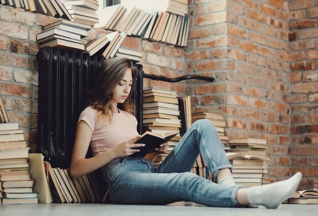 Mujer joven leyendo un libro en casa