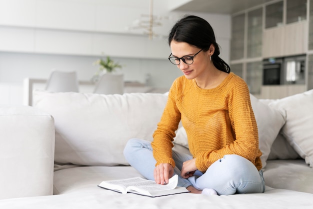 Foto gratuita mujer joven leyendo un libro en casa