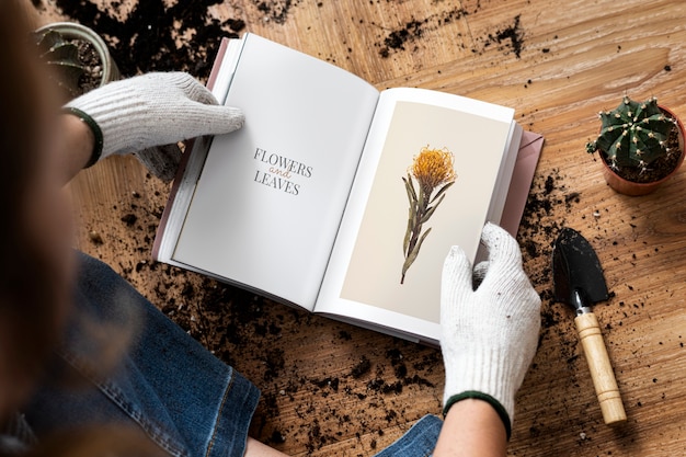 Mujer joven leyendo un libro sobre jardinería