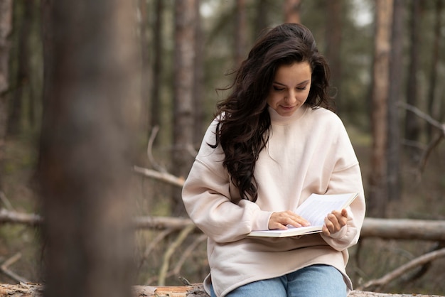 Mujer joven leyendo en la naturaleza