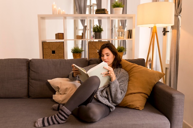 Foto gratuita mujer joven leyendo en la sala de estar