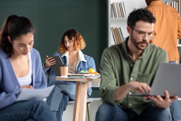 Mujer joven leyendo desde la tableta durante la sesión de estudio