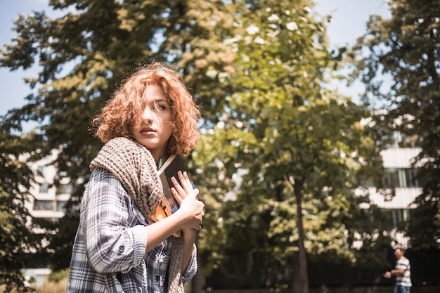 Mujer joven con libro en el parque