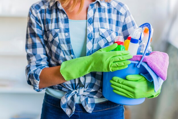 Mujer joven limpiando la casa