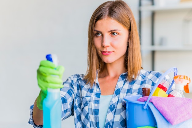 Mujer joven limpiando la casa