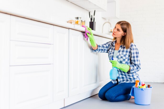 Mujer joven limpiando la casa