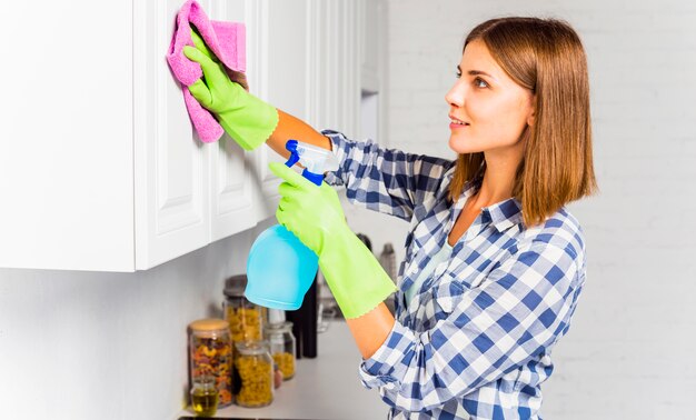 Mujer joven limpiando la casa