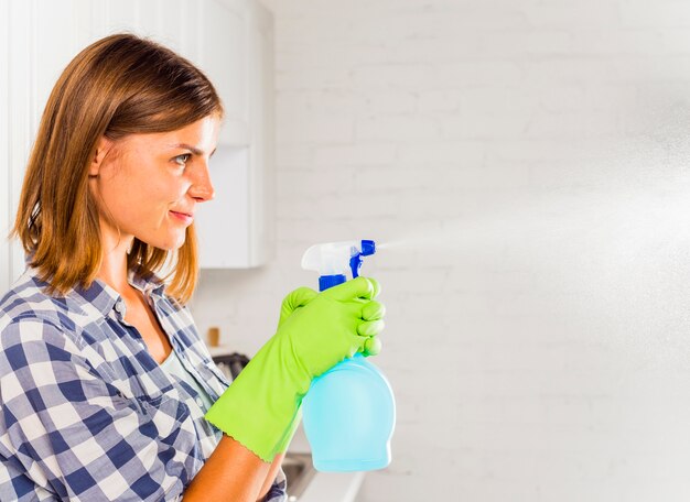 Mujer joven limpiando la casa