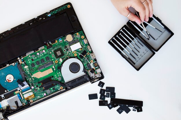 Mujer joven limpiando el teclado de su computadora portátil