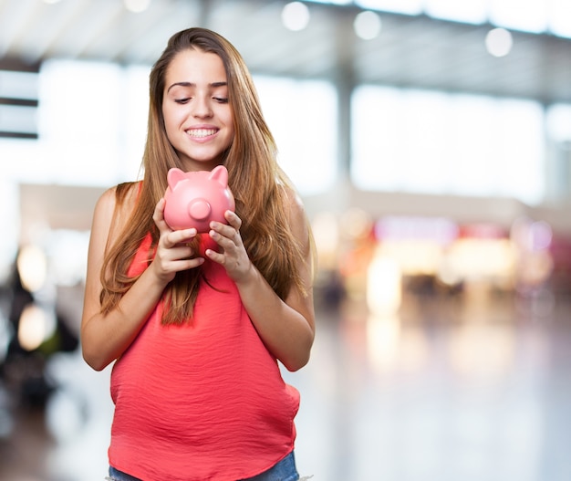 mujer joven linda de ahorro con una hucha