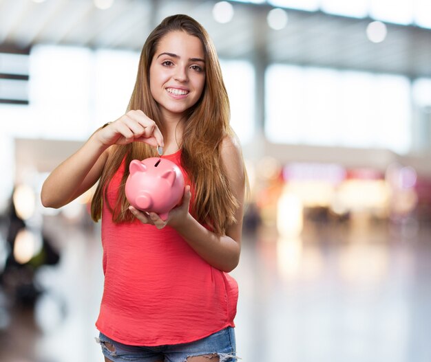 mujer joven linda de ahorro con una hucha